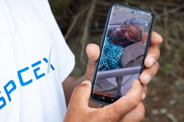 Karma Gyaljen, a relative of mountaineer Dawa Sherpa, shows a photograph of Dawa Sherpa undergoing treatment in the intensive care unit (ICU) at HAMS Hospital in Kathmandu on June 5, 2026. The family of a Nepali climber who dragged himself off Mount Everest six days after being abandoned called for an investigation into rescue efforts, as doctors said on June 5 he is in a stable condition and recovering in hospital. Mountaineer Dawa Sherpa, 57, vanished in bitter conditions on the upper reaches of the world's highest mountain early on May 30. His family thought he was dead, and had even begun ritual mourning prayers. (Photo by PRABIN RANABHAT / AFP)