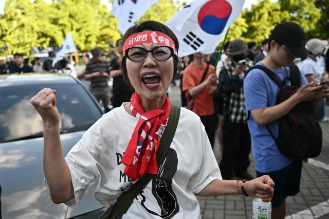 Protesters call for the suspension of ballot counting due to a shortage of ballot papers outside a counting station in Seoul on June 5, 2026. South Korean riot police cleared protesters from a Seoul polling station on June 5, after a 35-hour blockade sparked by a ballot shortage during local elections that also led the national election chief to resign. (Photo by Pedro PARDO / AFP)