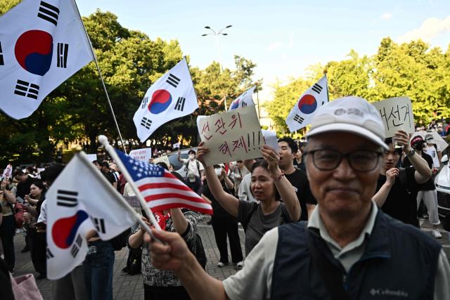 Protesters call for the suspension of ballot counting due to a shortage of ballot papers outside a counting station in Seoul on June 5, 2026. South Korean riot police cleared protesters from a Seoul polling station on June 5, after a 35-hour blockade sparked by a ballot shortage during local elections that also led the national election chief to resign. (Photo by Pedro PARDO / AFP)