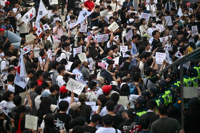 Protesters call for the suspension of ballot counting due to a shortage of ballot papers outside a counting station in Seoul on June 5, 2026. South Korean riot police cleared protesters from a Seoul polling station on June 5, after a 35-hour blockade sparked by a ballot shortage during local elections that also led the national election chief to resign. (Photo by Pedro PARDO / AFP)