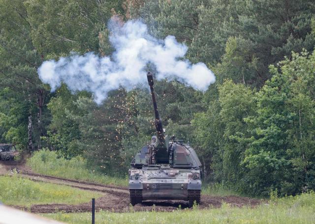 A self propelled howitzer Panzerhaubitze PzH 2000 of the German armed forces Bundeswehr fires during an exercise of the Panzergrenadier (armoured infantrymen) Training Bataillon 92 during the so-called Spotters' Day at the military training area in Munster, northern Germany, on June 5, 2026. Along with nine other locations, the Munster site is hosting the Bundeswehr Day open day of the German armed forces on June 6, 2026. (Photo by FOCKE STRANGMANN / AFP)