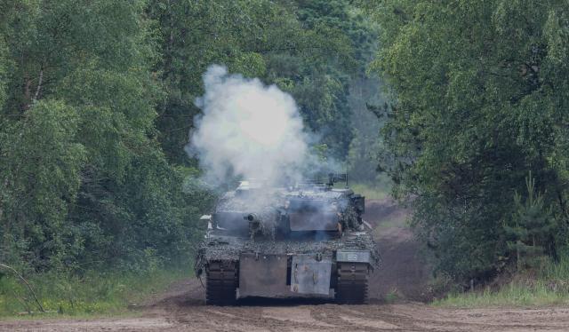 A Leopard 2A6 tank of the German armed forces Bundeswehr fires during an exercise of the Panzergrenadier (armoured infantrymen) Training Bataillon 92 during the so-called Spotters' Day at the military training area in Munster, northern Germany, on June 5, 2026. Along with nine other locations, the Munster site is hosting the Bundeswehr Day open day of the German armed forces on June 6, 2026. (Photo by FOCKE STRANGMANN / AFP)