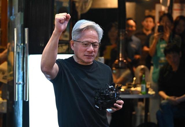 Nvidia CEO Jensen Huang speaks to reporters during a dinner with SK Group Chairman Chey Tae-won, LG Group Chairman Koo Kwang-mo and Naver founder and Chairman Lee Hae-jin at a Korean barbecue restaurant in Seoul on June 5, 2026. Nvidia chief executive Jensen Huang arrived in Seoul on June 5, for a packed schedule of meetings with tech leaders, promising "some surprises" for South Korea while predicting robotics will be the country's next major growth sector. (Photo by Jung Yeon-je / AFP)