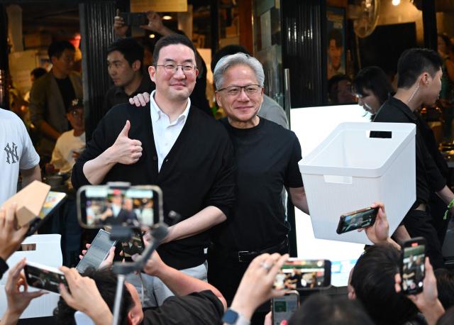 Nvidia CEO Jensen Huang (R) poses for a photo with LG Group Chairman Koo Kwang-mo (L) during their dinner at a Korean barbecue restaurant in Seoul on June 5, 2026. Nvidia chief executive Jensen Huang arrived in Seoul on June 5, for a packed schedule of meetings with tech leaders, promising "some surprises" for South Korea while predicting robotics will be the country's next major growth sector. (Photo by Jung Yeon-je / AFP)