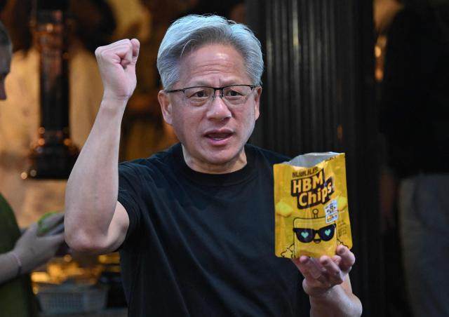 Nvidia CEO Jensen Huang hands out "HBM chip" snacks to reporters during a dinner with SK Group Chairman Chey Tae-won, LG Group Chairman Koo Kwang-mo and Naver founder and Chairman Lee Hae-jin at a Korean barbecue restaurant in Seoul on June 5, 2026. Nvidia chief executive Jensen Huang arrived in Seoul on June 5, for a packed schedule of meetings with tech leaders, promising "some surprises" for South Korea while predicting robotics will be the country's next major growth sector. (Photo by Jung Yeon-je / AFP)