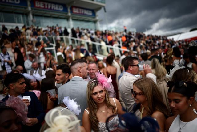 Racegoers attend the opening day of the Epsom Derby Festival horse racing event in Surrey, southern England on June 5, 2026. Held at numerous racecourses across the UK, Ladies Day combines horse racing with a celebration of female fashion (Photo by Henry Nicholls / AFP)