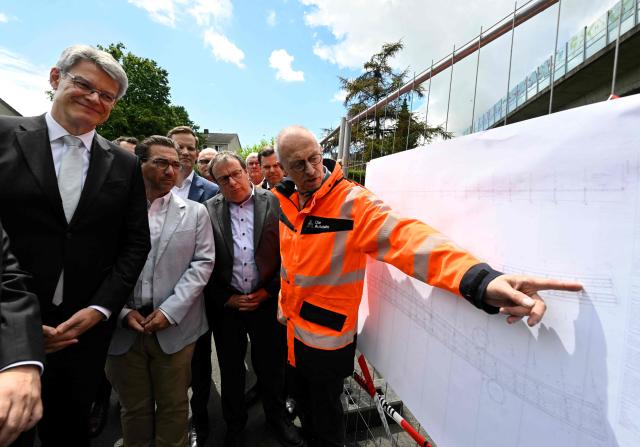 German Transport Minister Patrick Schnieder (L) listens to Dirk Brandenburger (R), technical director at Germany's highway operator Die Autobahn GmbH giving explanations as he visits on June 5, 2026 the dilapidated Nord-Bruecke bridge crossing the Rhine in Bonn, western Germany, after it had to be closed due to severe damage. (Photo by Roberto Pfeil / AFP)