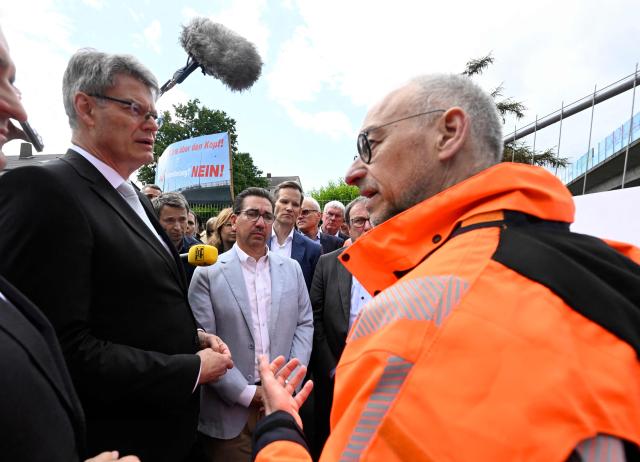 German Transport Minister Patrick Schnieder (L) listens to Dirk Brandenburger (R), technical director at Germany's highway operator Die Autobahn GmbH giving explanations as he visits on June 5, 2026 the dilapidated Nord-Bruecke bridge crossing the Rhine in Bonn, western Germany, after it had to be closed due to severe damage. (Photo by Roberto Pfeil / AFP)