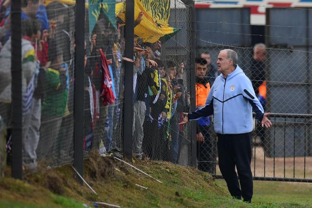Uruguay's fnational football team coach, Argentinian Marcelo Bielsa, greets fans during a farewell activity with children ahead of the departure of the sqad for the FIFA World Cup 2026, at the Tito LOpez Lopez stadium in Pando, Canelones department, Uruguay on June 5, 2026. (Photo by Dante FERNANDEZ / AFP)