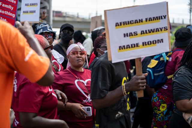 A protestor looks on as others hold placards during a march for peace and family diversity organised by a coalition of feminist and human rights organisations in Accra on June 5, 2026. The march came a week after Ghana's parliament passed a controversial anti-LGBTQ bill that would further restrict LGBTQ rights and criminalise the promotion of LGBTQ activities. Demonstrators also protested against the fourth Pan-African Conference on Family Values, currently held for the first time in Accra. (Photo by Claudia LACAVE / AFP)