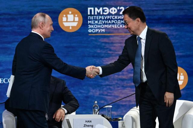Russian President Vladimir Putin shakes hands with Vice President of the People’s Republic of China Han Zheng during the plenary session of the St. Petersburg International Economic Forum (SPIEF) in Saint Petersburg on June 5, 2026. (Photo by OLGA MALTSEVA / AFP)