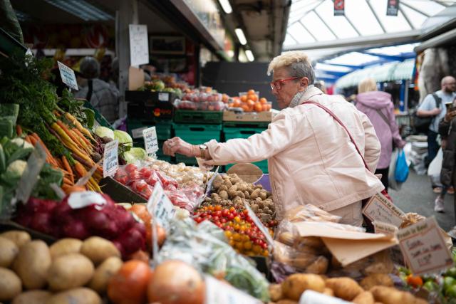 Shoppers buy fruit and vegetables from a stall at Bury Market in Bury, Greater Manchester on June 5, 2026. (Photo by Oli SCARFF / AFP)