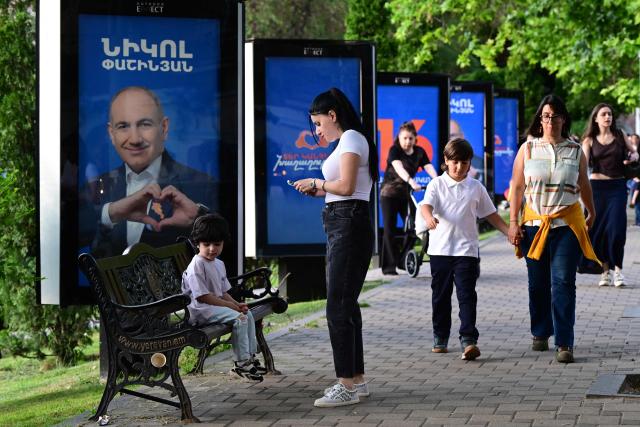 People walk past campaign posters of Armenian Prime Minister Nikol Pashinyan's Civil Contract party in Yerevan on June 5, 2026, days ahead of the parliamentary elections. (Photo by Karen MINASYAN / AFP)