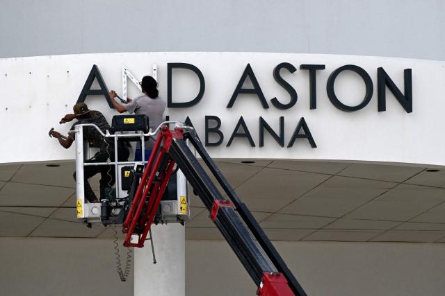 Maintenance workers remove the sign from the Hotel Grand Aston in Havana on June 5, 2026. The Asian group Archipelago International, which came to operate six hotels on the island under the Aston brand, has brought its activities in Cuba to an end. (Photo by YAMIL LAGE / AFP)