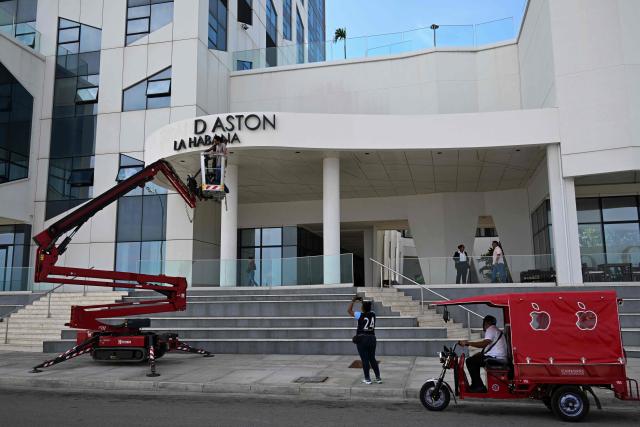 Maintenance workers remove the sign from the Hotel Grand Aston in Havana on June 5, 2026. The Asian group Archipelago International, which came to operate six hotels on the island under the Aston brand, has brought its activities in Cuba to an end. (Photo by YAMIL LAGE / AFP)