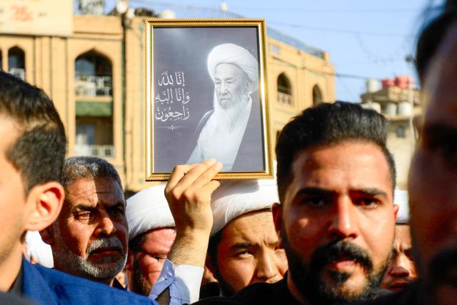 A mourner grieves with others with a picture of Iraqi Shia Muslim cleric and Grand Ayatollah Mohammad Ishaq al-Fayyad, during his funeral near the shrines of Imam Hussein and Abbas in Iraq's central holy city of Karbala on June 5, 2026. (Photo by Karrar Jabbar / AFP)