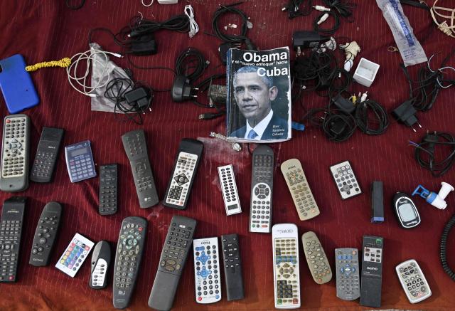 Electronic items including television remote controls, cables and a calculator are displayed for sale by a street vendor alongside a book featuring former US president Barack Obama in Havana on June 5, 2026. (Photo by YAMIL LAGE / AFP)