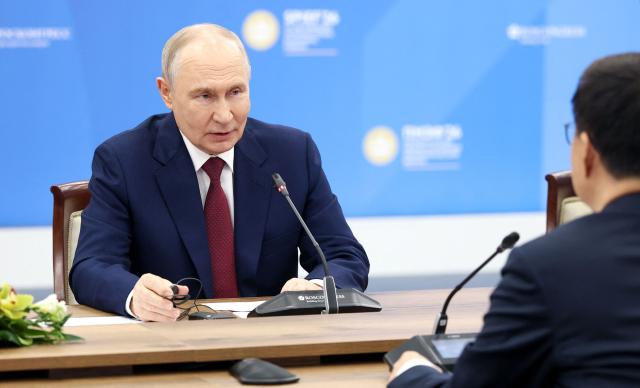In this pool photograph distributed by the Russian state agency Sputnik, Russia's President Vladimir Putin and Vice President of the People’s Republic of China Han Zheng hold a meeting on the sidelines of the St. Petersburg International Economic Forum (SPIEF) in Saint Petersburg on June 5, 2026. (Photo by Valery SHARIFULIN / POOL / AFP)