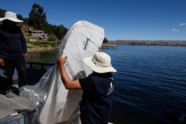Workers from the National Office of Electoral Processes (ONPE) load electoral material onto a boat bound for the islands of Amantani in Lake Titicaca in Puno, southern Peru, on June 5, 2026. Right-wing candidate Keiko Fujimori and leftist Roberto Sanchez will face off in Peru's presidential runoff on June 7, 2026. (Photo by Juan Carlos CISNEROS / AFP)
