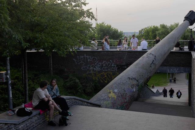 People relax on a warm summer evening in Kyiv on June 5, 2026, amid the Russian invasion of Ukraine. (Photo by Tetiana DZHAFAROVA / AFP)