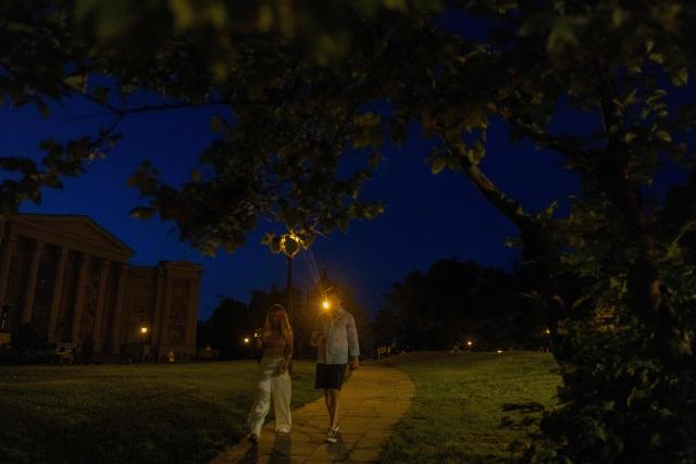 Pedestrians walk in the park in the evening in Kyiv on June 5, 2026, amid the Russian invasion of Ukraine. (Photo by Tetiana DZHAFAROVA / AFP)