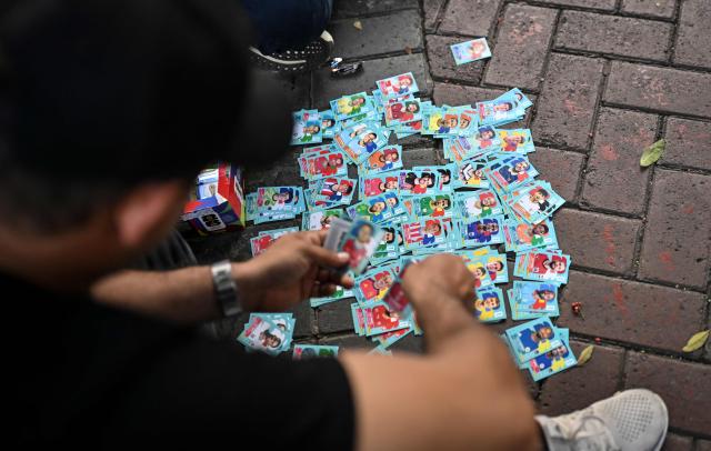A football fan trades official FIFA 2026 World Cup stickers at Kennedy Park in Lima on June 5, 2026. (Photo by MARTIN BERNETTI / AFP)