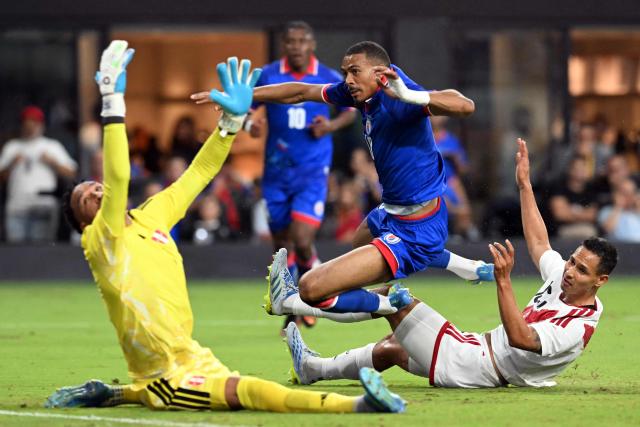 Haiti's forward #18 Wilson Isidor (C) jumps over a Peruvian defender to beat Peru's goalkeeper #01 Pedro Gallese (L) and score a goal during the international friendly football match between Haiti and Peru at Nu Stadium in Miami, Florida on June 5, 2026. (Photo by CHANDAN KHANNA / AFP)
