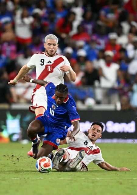 Haiti's midfielder #10 Jean-Ricner Bellegarde falls as he attempts to control the ball away from Peru's defender #08 Erick Noriega and Peru's forward #09 Adrian Ugarriza during the international friendly football match between Haiti and Peru at Nu Stadium in Miami, Florida on June 5, 2026. (Photo by CHANDAN KHANNA / AFP)
