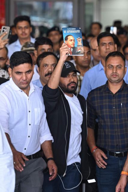 Founder of the Cockroach Janta Party (CJP), Abhijeet Dipke displays the book 'My Autobiography' by the Indian social reformer Dr. B. R. Ambedkar upon his arrival at the airport in New Delhi on June 6, 2026. (Photo by Arun SANKAR / AFP)