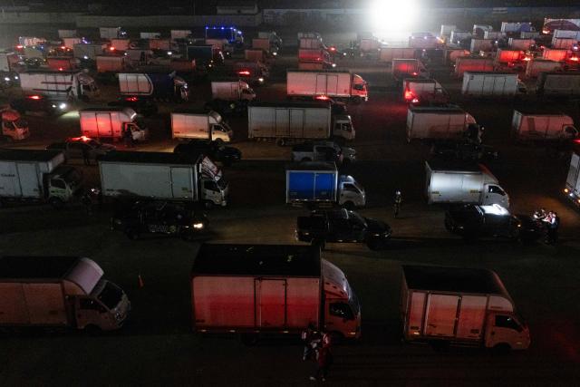 Aerial view of trucks loaded with election material at Peru's National Office of Electoral Processes (ONPE) in Lima on June 5, 2026. Right-wing candidate Keiko Fujimori and leftist Roberto Sanchez will face off in Peru's presidential runoff on June 7, 2026. (Photo by ERNESTO BENAVIDES / AFP)