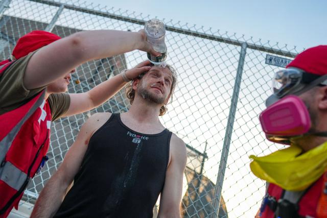 A medic pours water into a protester's eye after he was pepper-sprayed by federal agents outside Delaney Hall, which is being used as an Immigration and Customs Enforcement (ICE) detention center, in Newark, New Jersey, on June 5, 2026. The US state of New Jersey on June 2, 2026, sued the private prison company that runs a migrant detention center where protesters have rallied for several days over allegedly poor conditions at the jail. The lawsuit against GEO Group demands that local health authorities be allowed full access to Delaney Hall, one of many facilities holding people rounded up in US President Donald Trump's mass deportation sweep. (Photo by Ryan MURPHY / AFP)