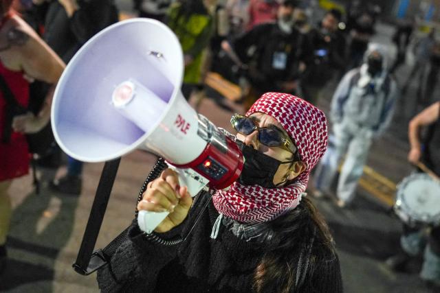 A protester uses a bullhorn to speak to detainees inside Delaney Hall, which is being used as an Immigration and Customs Enforcement (ICE) detention center, in Newark, New Jersey, on June 5, 2026. The US state of New Jersey on June 2, 2026, sued the private prison company that runs a migrant detention center where protesters have rallied for several days over allegedly poor conditions at the jail. The lawsuit against GEO Group demands that local health authorities be allowed full access to Delaney Hall, one of many facilities holding people rounded up in US President Donald Trump's mass deportation sweep. (Photo by Ryan MURPHY / AFP)