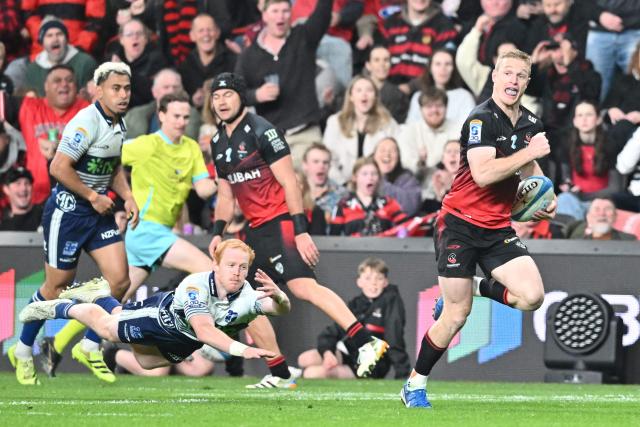Crusaders' Johnny McNicholl (R) charges forward to score a try during the Super Rugby Pacific Quarter final match between the Canterbury Crusaders and Blues at One New Zealand Stadium in Christchurch on June 6, 2026. (Photo by Sanka VIDANAGAMA / AFP)
