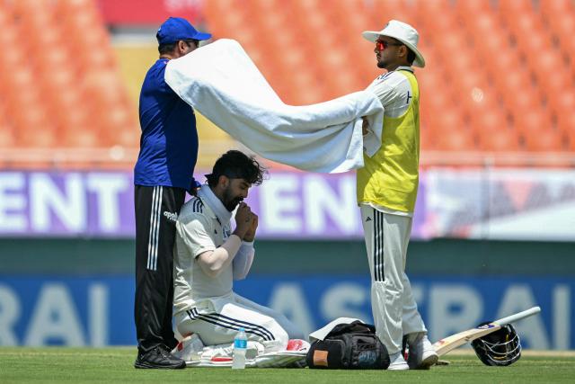 India's KL Rahul (C) takes shelter under a towel from the sun during a break in the first day of the only Test cricket match between India and Afghanistan at the Maharaja Yadavindra Singh International Cricket Stadium on the outskirts of Chandigarh on June 6, 2026. (Photo by Shammi MEHRA / AFP)