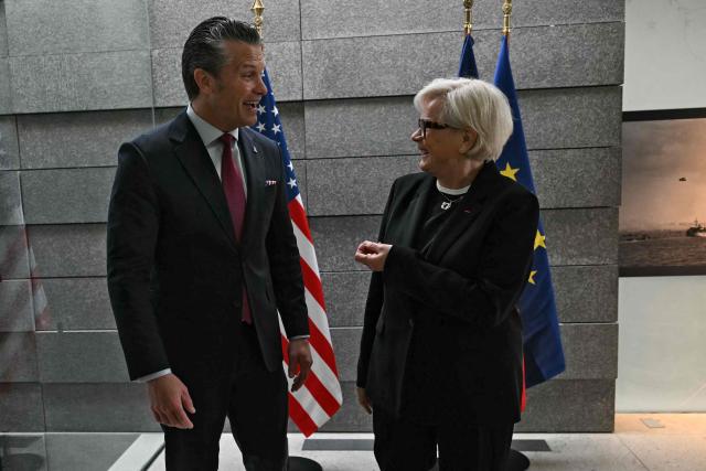 French Minister of the Armed Forces and Veterans Catherine Vautrin (R) welcomes US Secretary of War Pete Hegseth ahead of a ceremony marking the 82nd anniversary of the D-Day landings at the Normandy American Cemetery in Colleville-sur-Mer, northwestern France, on June 6, 2026. (Photo by LOU BENOIST / AFP)
