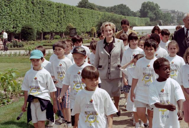 (FILES) French First Lady Bernadette Chirac, president of the Fondation Hopitaux de France, walks on June 11, 1996 in the Jardin des Plantes in Paris with chidren to participate "pieces jaunes" (yellow coins) fundraising operation, aimed at improving the lives of hospitalised children and adolescents. Bernadette Chirac, widow of former President of the Republic Jacques Chirac, died on June 5, 2026 in the evening at the age of 93, her daughter Claude Chirac told AFP on June 6, 2026. (Photo by Gerard FOUET / AFP)