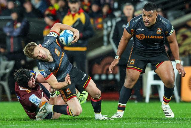 Chiefs' Damian McKenzie is tackled during the Super Rugby Qualifying Final match between the Chiefs and Queensland Reds at FMG Stadium in Hamilton on June 6, 2026. (Photo by DJ MILLS / AFP)