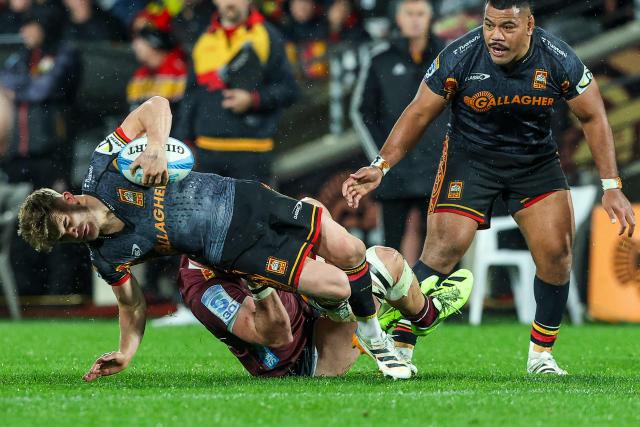 Chiefs' Damian McKenzie (L) is tackled during the Super Rugby Qualifying Final match between the Chiefs and Queensland Reds at FMG Stadium in Hamilton on June 6, 2026. (Photo by DJ MILLS / AFP)