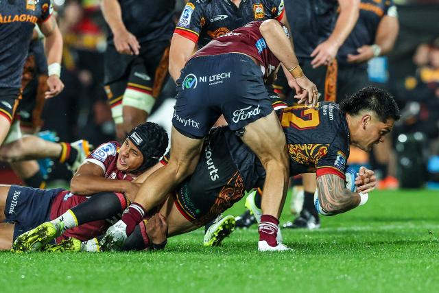Chiefs' Quinn Tupaea (C) is tackled during the Super Rugby Qualifying Final match between the Chiefs and Queensland Reds at FMG Stadium in Hamilton on June 6, 2026. (Photo by DJ MILLS / AFP)