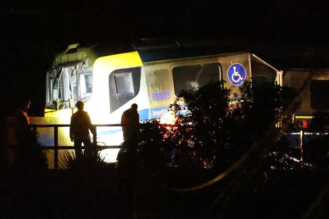 Emergency services workers inspect a train that derailed at Khandallah Station in New Zealand's capital Wellington on June 6, 2026. Around six people were injured when a train derailed in New Zealand's capital Wellington on June 6, police said. (Photo by BEN STRANG / AFP)