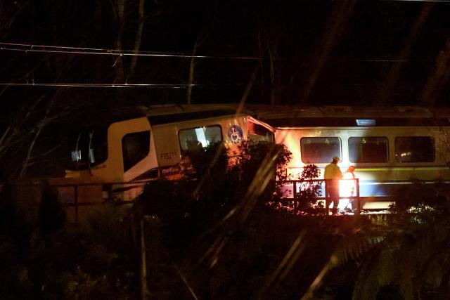Emergency services workers inspect a train that derailed at Khandallah Station in New Zealand's capital Wellington on June 6, 2026. Around six people were injured when a train derailed in New Zealand's capital Wellington on June 6, police said. (Photo by BEN STRANG / AFP)