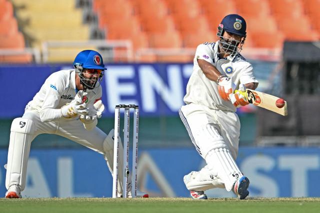 India's Rishabh Pant (R) plays a shot as Afghanistan's wicketkeeper Afsar Zazai watches during the first day of the only Test cricket match between India and Afghanistan at the Maharaja Yadavindra Singh International Cricket Stadium on the outskirts of Chandigarh on June 6, 2026. (Photo by Shammi MEHRA / AFP)