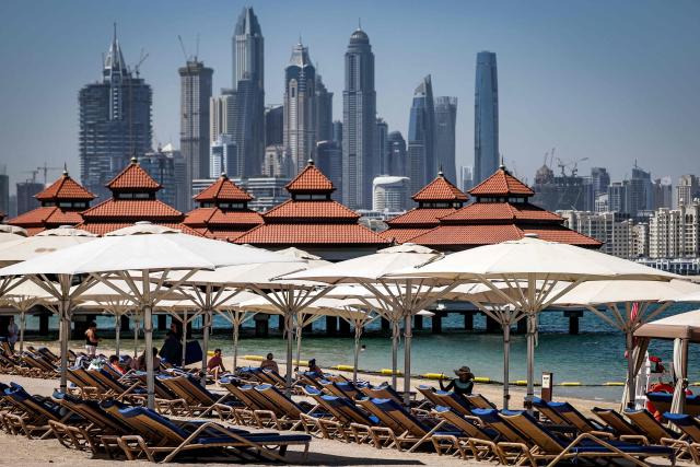 People sit along the beach at the Anantara The Palm Dubai Resort in Dubai on June 6, 2026. (Photo by FADEL SENNA / AFP)