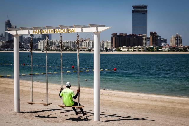 A man rides a swing along the beach at the Anantara The Palm Dubai Resort in Dubai on June 6, 2026. (Photo by FADEL SENNA / AFP)