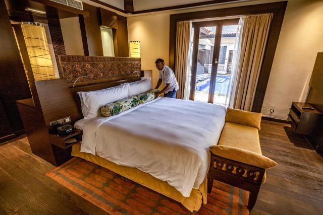 An employee arranges a bed in a room at the Anantara The Palm Dubai Resort in Dubai on June 6, 2026. (Photo by FADEL SENNA / AFP)