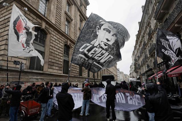 Demonstrators wave a flag showing a portrait of Clément Meric (C) and a Paris-Banlieue Antifascist Action (AFAPB) flag (L) as they take part in a march to mark the 13th anniversary of the murder in 2013 of anti-fascist militant Clément Méric following a brawl with skinheads, in Paris on June 6, 2026. (Photo by STEPHANE DE SAKUTIN / AFP)