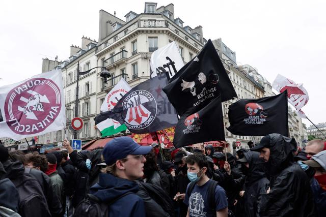 Demonstrators wave Rouen Antifascist (L), Paris-Banlieue Antifascist Action (AFAPB) (C) and Reims Popular Self-Defence (R) flags as they take part in a march to mark the 13th anniversary of the murder in 2013 of anti-fascist militant Clément Méric following a brawl with skinheads, in Paris on June 6, 2026. (Photo by STEPHANE DE SAKUTIN / AFP)