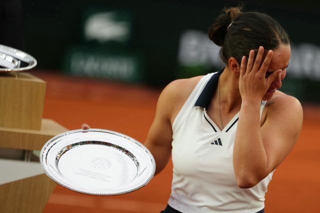 France's Ksenia Chasteau reacts as she poses with her trophy after being defeated by Netherlands' Diede de Groot in the end of their women's singles wheelchair final match on day 14 of the French Open tennis tournament on Court Suzanne-Lenglen at the Roland-Garros Complex in Paris on June 6, 2026. (Photo by Dimitar DILKOFF / AFP)