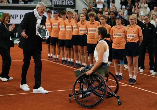France's Ksenia Chasteau (C) receives her trophy from French Tennis Federation's President Gilles Moretton (2ndL) after being defeating by Netherlands' Diede de Groot in their women's singles wheelchair final match on day 14 of the French Open tennis tournament on Court Suzanne-Lenglen at the Roland-Garros Complex in Paris on June 6, 2026. (Photo by Dimitar DILKOFF / AFP)