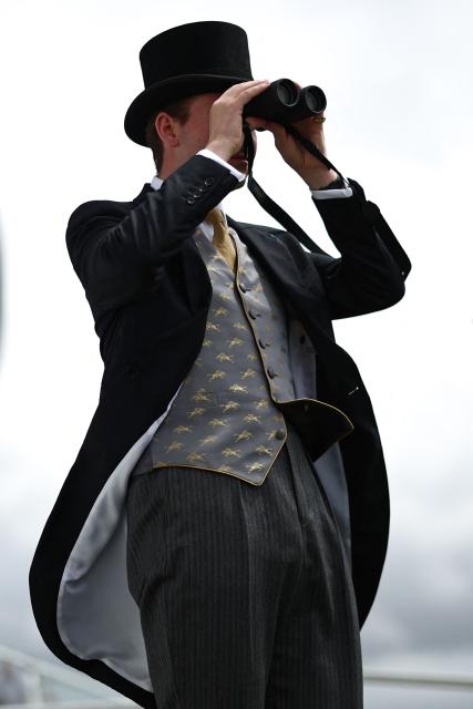 A racegoer uses a pair of binoculars ahead of racing on the second day of the Epsom Derby Festival horse racing event in Surrey, southern England on June 6, 2026. (Photo by Henry Nicholls / AFP)